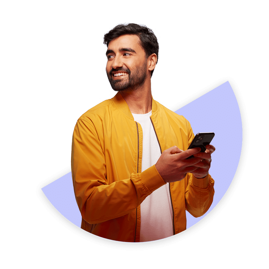 Man looking over his shoulder smiling and holding a phone